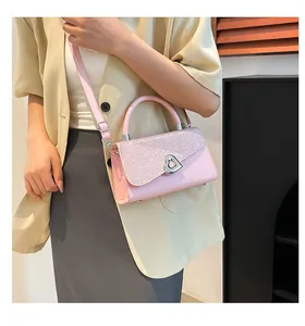Détail du sac à main rose à paillettes avec un fermoir tournant en forme de cœur
