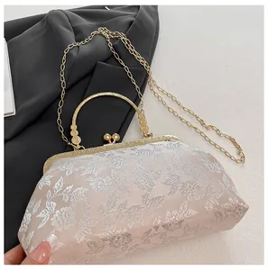 Détail de la broderie florale et du fermoir boule doré sur ce sac de soirée vintage