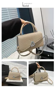 Détail du sac à main pailleté or champagne avec fermoir argenté en forme de cœur brillant
