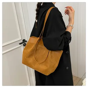 Detailansicht der braunen Tragetasche mit Wildleder- und Leder-Patchwork an der Schulter
