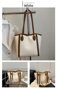 Detail of minimalist cream tote bag with brown straps and elegant leather texture