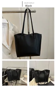 Macro detail of the premium black PU leather texture and reinforced stitching on tote bag
