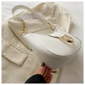 Detail of white crescent shoulder bag with golden D-ring and smooth vegan leather finish