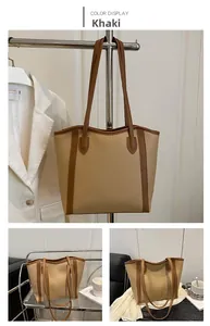 Detail view of khaki faux leather tote bag with brown straps and refined stitching