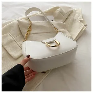 Detail of white leather crescent bag featuring a golden D-ring buckle and chain strap