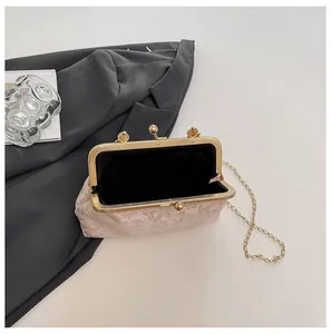 Détail de l'intérieur noir spacieux et du fermoir à boule doré du sac brodé à fleurs