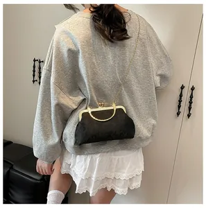 Détail du sac brodé de fleurs noires vintage avec cadre doré et bandoulière chaîne