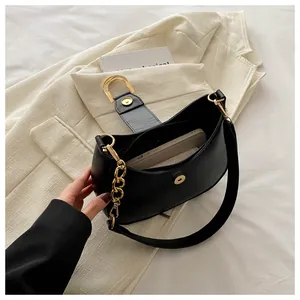 Detail of black faux leather crescent bag showing internal storage for a smartphone