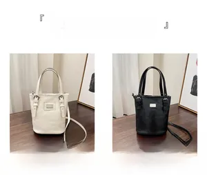Detailed comparison of minimalist cream and black leather bucket bags in an elegant interior