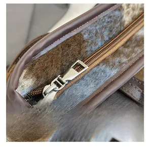 Detail showing smooth silver zipper and soft brown plush faux fur fabric of the bag