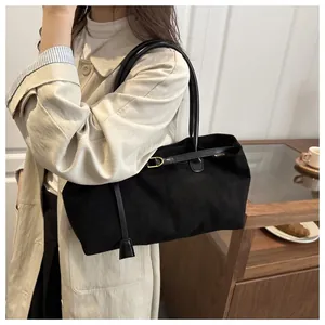 Close-up of matte black large tote bag with elegant shoulder straps and metal buckle details