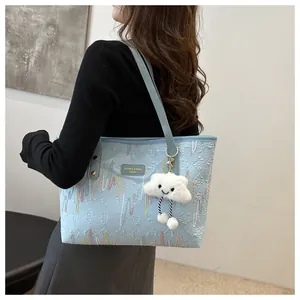 Detail of light blue tote bag with 3D letter patterns and a cute cloud charm accessory