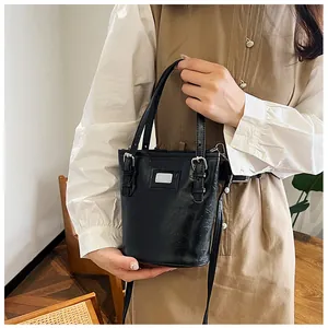 Detail of a retro black bucket bag in vintage oil wax leather with silver hardware finish