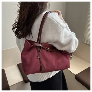 Burgundy matte leather large tote bag on model's shoulder for casual commuter style