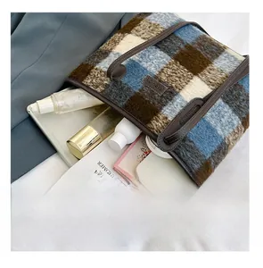 Detailed view of spacious plaid wool tote bag showing storage for tablet and essentials