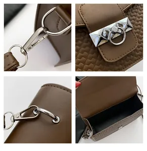 Detailed view of silver metal rotary lock and geometric textured flap on dark brown bag