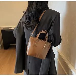 Dettaglio di una piccola borsa a tracolla in pelle marrone mostrata indossata