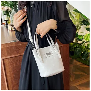 Model showing white oil wax leather bucket bag with metal buckle and adjustable strap
