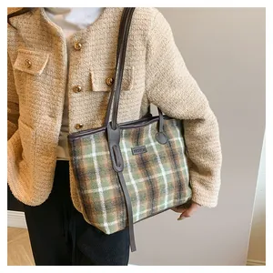 Detail of vintage plaid woolen tote bag with leather strap and fashion leather patch
