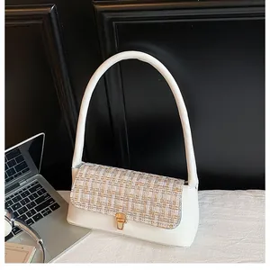 Detail of white leather shoulder bag featuring beige tweed flap and gold metal lock