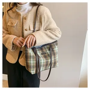 Detail of green plaid wool tote bag with FASHION leather patch and brown slim strap