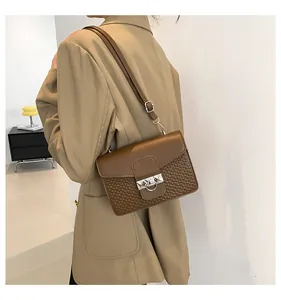 Detail of retro textured brown crossbody bag with color-block design and metal clasp
