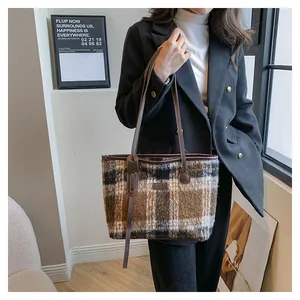 Detail of checkered wool tote bag with leather strap and fashion leather patch on the front