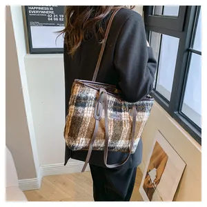 Detail of plaid faux fur tote bag with leather straps and Fashion label on shoulder