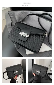 Macro view of black crossbody bag featuring woven texture and silver metal ring buckle