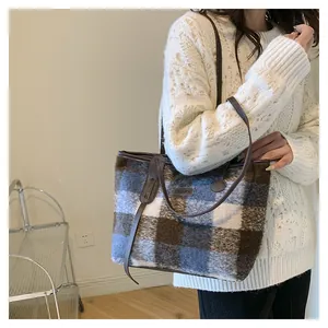Detail of checkered wool tote bag showing FASHION leather patch and plush texture