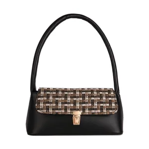 Minimalist black leather and tweed underarm bag with a vintage gold clasp closure
