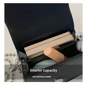 Capacité interne du mini sac en cuir noir avec chaîne argentée et rangement rouge
