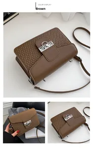 Detail view of brown textured crossbody bag with silver buckle and braided finish