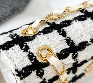Close-up of the woven gold chain strap and tweed fabric texture on the shoulder bag