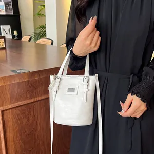 White oil wax leather bucket bag with silver buckles shown in a modern interior setting