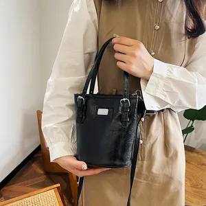 Retro black oil wax leather bucket bag with silver buckle strap shown on a model