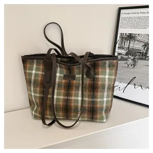 Detailed view of vintage wool plaid tote bag with brown leather label and fashion logo