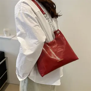 Sac sous le bras en cuir ciré rouge foncé avec logo doré et chaîne argentée