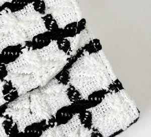 Detailed close-up showing the black and white tweed fabric texture and woven fiber patterns