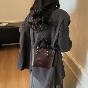 Mini borsa tote in pelle marrone lucida con borchie dorate e tracolla rimovibile