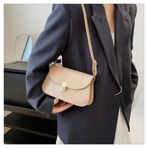 Détail d'un sac selle crème chic montrant le fermoir doré et la texture lisse du similicuir