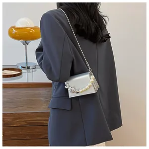 Détail du mini sac bandoulière argenté avec poignée en perles et chaîne à billes