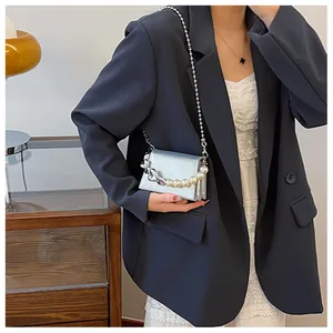 Détail du mini sac bandoulière argenté avec poignée perle et chaîne sur modèle