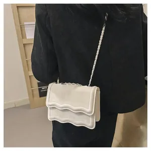 Detail of off-white crossbody bag with wavy cloud-edge flap and metal chain strap