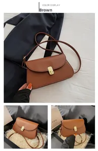 Sacoche marron avec rabat incurvé et fermoir doré présentée dans une boîte cadeau de luxe
