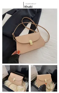 Détail du sac selle en cuir kaki avec boucle dorée et emballage cadeau premium