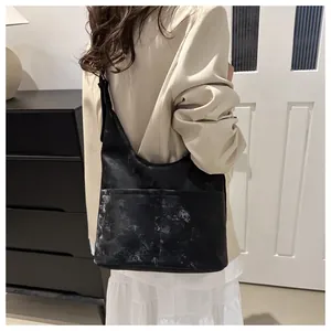 Schicke schwarze Totebag mit Marmordruck, getragen von Model im beigen Anzug