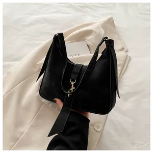 Detail of black matte hobo bag featuring a knotted shoulder strap and gold metal buckle