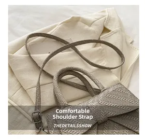 Close-up of gray woven texture handbag with comfortable shoulder strap detail