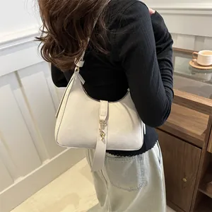 Chic ivory faux leather baguette shoulder bag with gold buckle and long decorative ribbon
